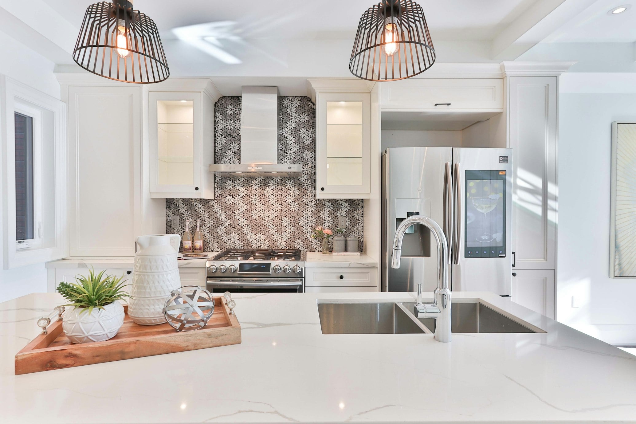 Luxury modern kitchen remodel featuring white quartz waterfall island countertop and tile backsplash