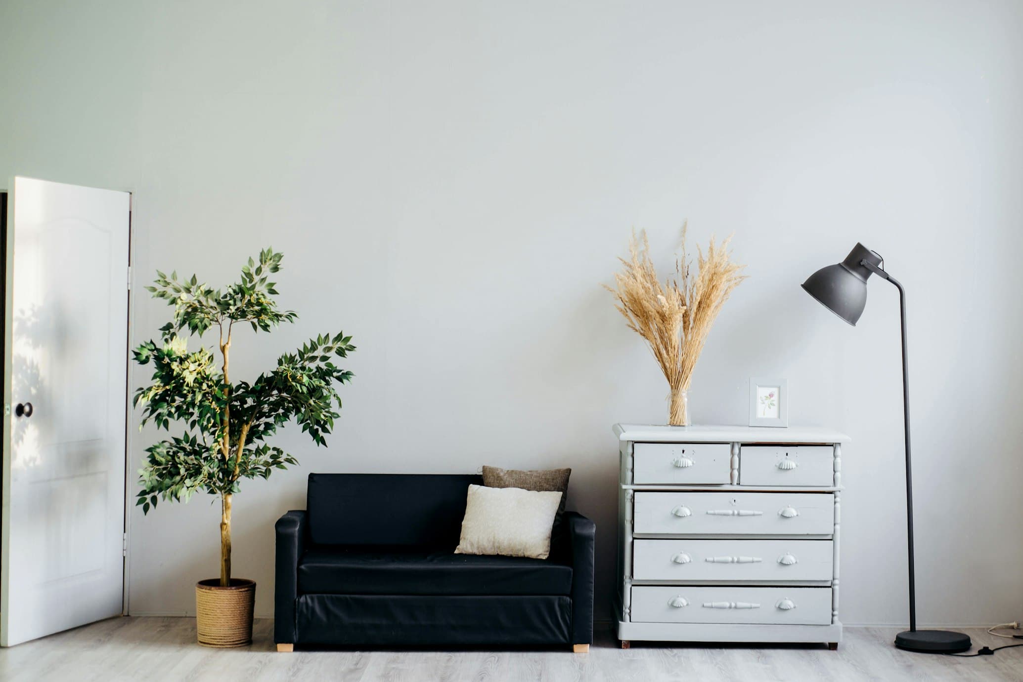 Minimalist living room interior featuring newly installed light oak hardwood flooring